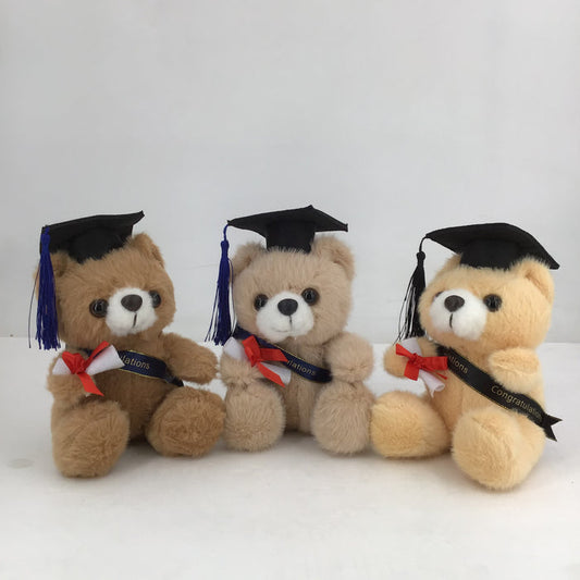 Three teddy bears wearing graduation caps and gowns on a white background