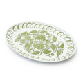 An oval white ceramic serving platter decorated with a light green floral pattern in the center and a scalloped green border, shown on a clean white background.