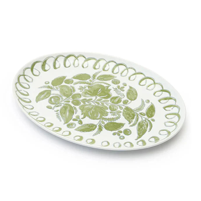 An oval white ceramic serving platter decorated with a light green floral pattern in the center and a scalloped green border, shown on a clean white background.