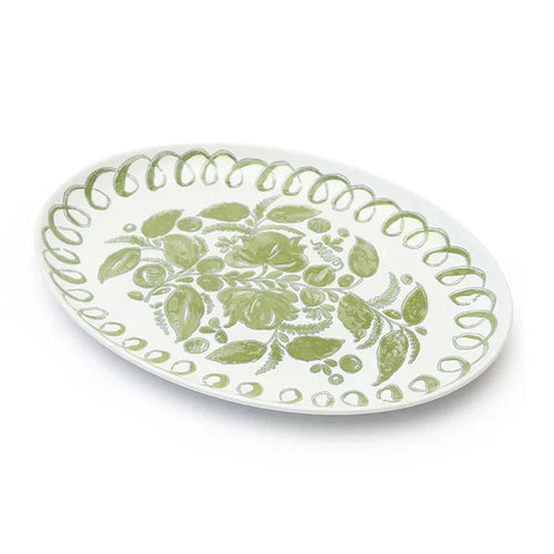 An oval white ceramic serving platter decorated with a light green floral pattern in the center and a scalloped green border, shown on a clean white background.