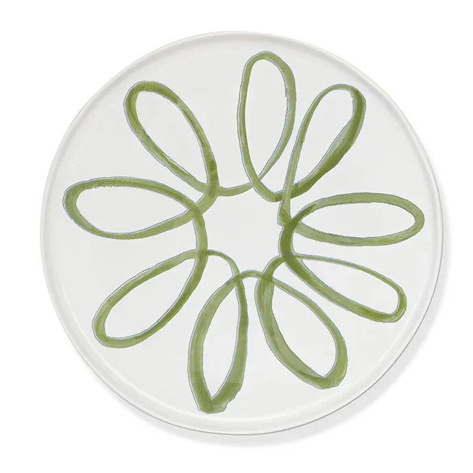 A round white plate featuring a hand-painted green floral or daisy-like pattern in the center, shown against a clean white background.