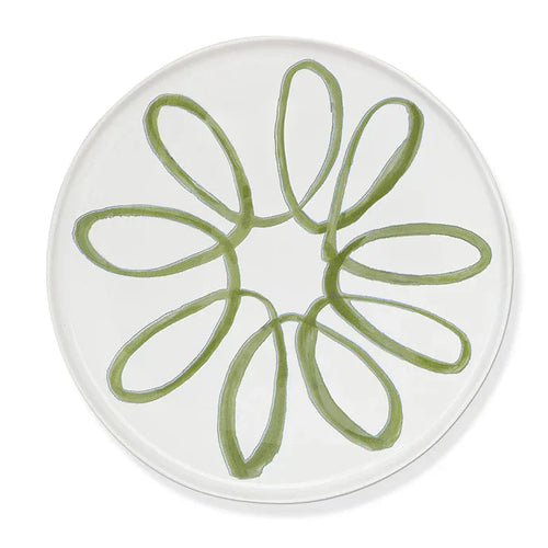 A round white plate featuring a hand-painted green floral or daisy-like pattern in the center, shown against a clean white background.