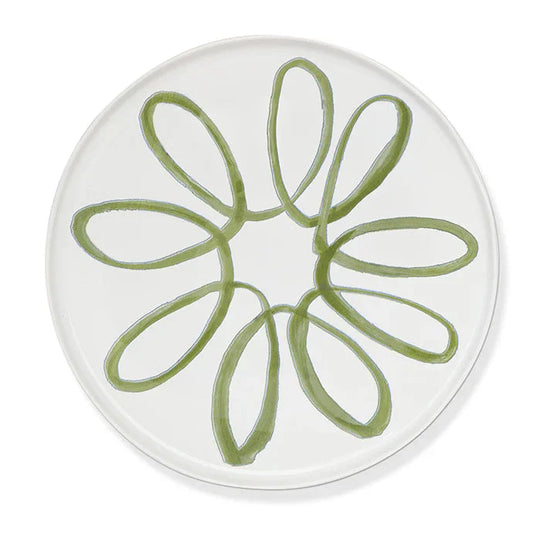 A round white plate featuring a hand-painted green floral or daisy-like pattern in the center, shown against a clean white background.