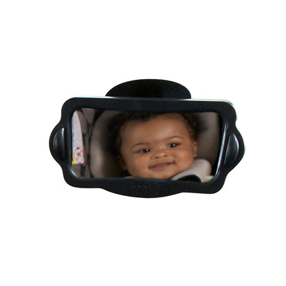 A curly-haired baby smiles in a car seat, reflected in the Baby View Mirror— a black-framed baby car mirror offering a multiangle view.