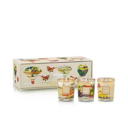 Set of three small candles with colorful designs in front of a decorative box on a white background