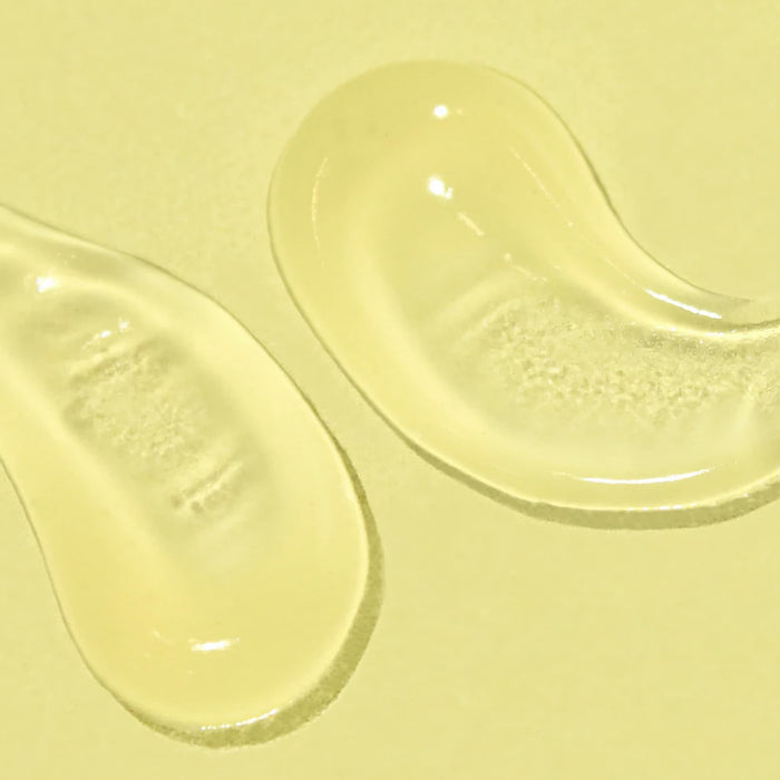 Two swipes of a clear gel SPF on a pale yellow background.