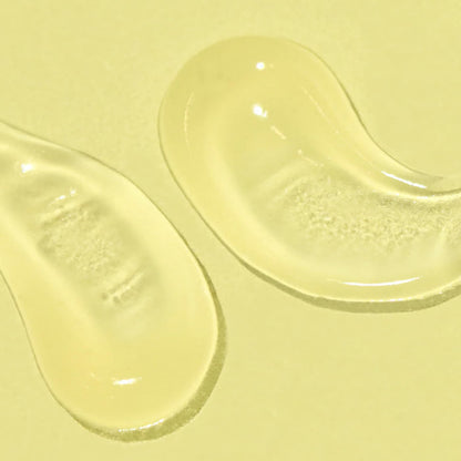 Two swipes of a clear gel SPF on a pale yellow background.