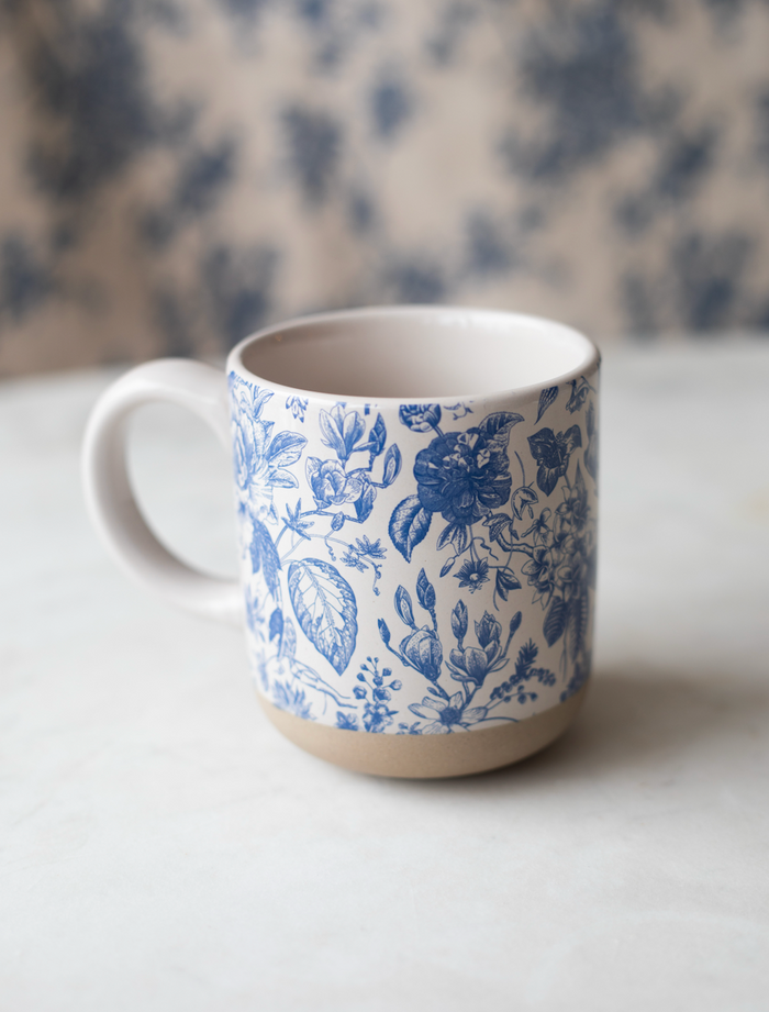 Stoneware mug with blue and white floral pattern.