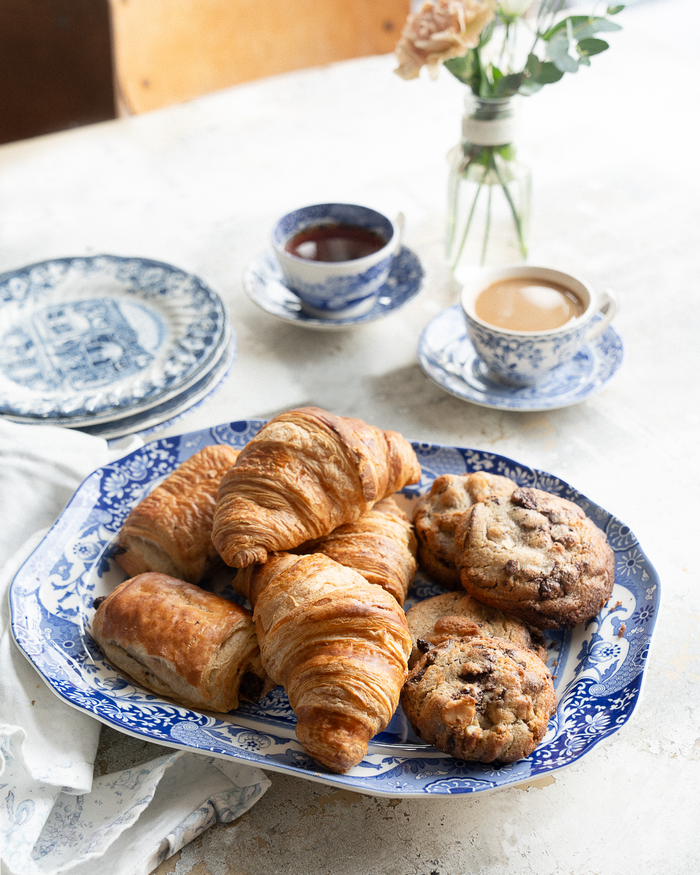 Vintage-style blue-and-white ceramic serving platter with pastries and cookies.