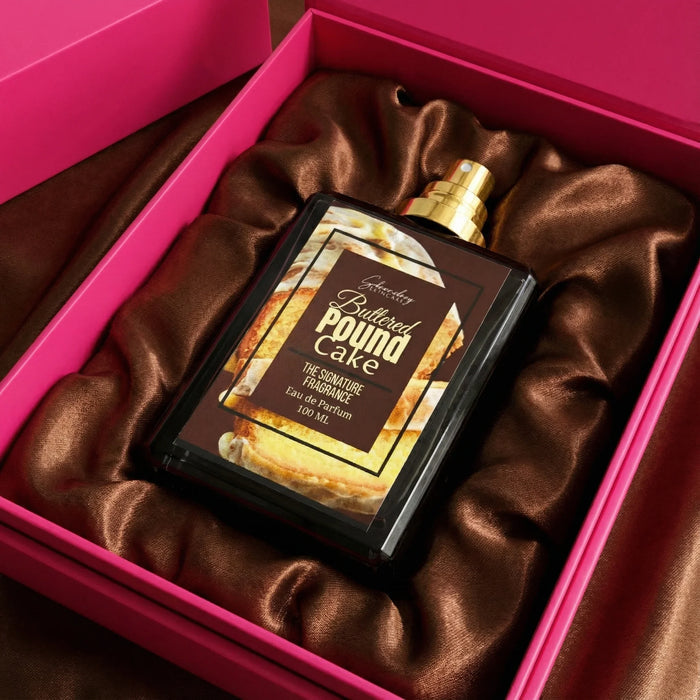 Buttered Pound Cake perfume bottle in black and gold, placed in a pink gift box with brown satin lining