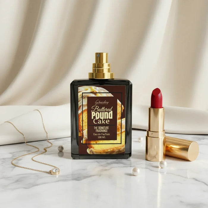 Buttered Pound Cake perfume bottle with red lipstick and gold necklace on marble surface