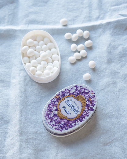 Tin of white violet mints with a decorative purple lid.
