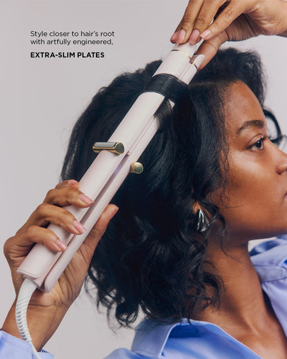 Person using a hair straightener on their hair with text highlighting 'Extra-slim plates'.