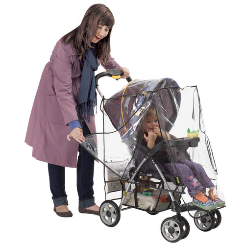A woman in a purple coat pushes a stroller with the Deluxe Stroller Weather Shield. Inside, a smiling child holds a green sippy cup. The stroller features handy under-seat storage.