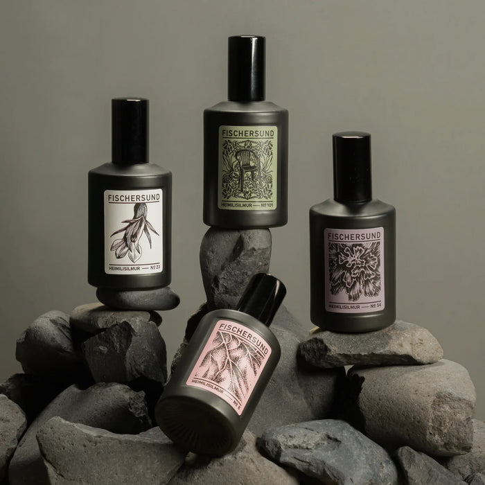Four Fischersund room spray bottles on stones with a neutral background
