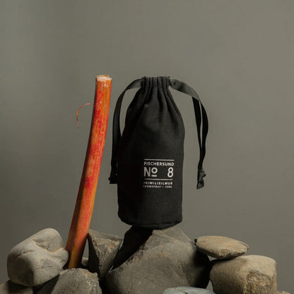 Black drawstring bag with 'Fischersund No. 8' text on rocks against a gray background