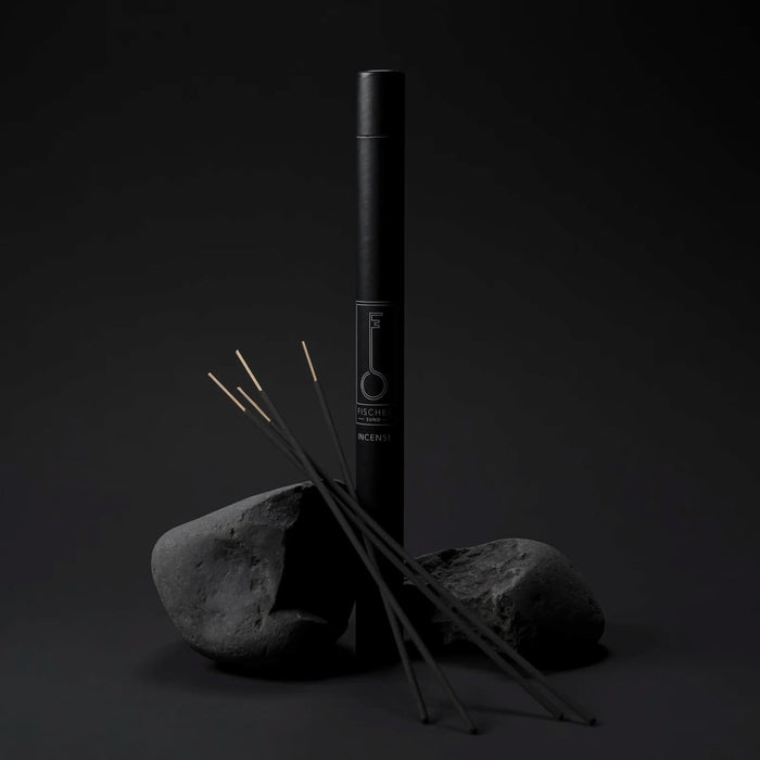 Black incense stick tube by Fischersund with incense sticks on a dark background