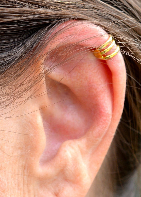 Model wearing gold mini ear cuff, non-piercing spiral wire boho ear jewelry, close-up side view