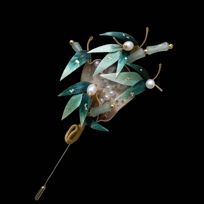 Close-up of green silk velvet bamboo leaves with gold details and pearls on Ronghua fan brooch
