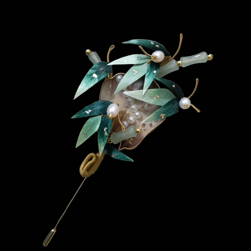 Close-up of green silk velvet bamboo leaves with gold details and pearls on Ronghua fan brooch