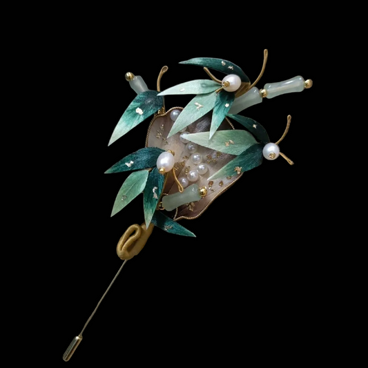 Close-up of green silk velvet bamboo leaves with gold details and pearls on Ronghua fan brooch