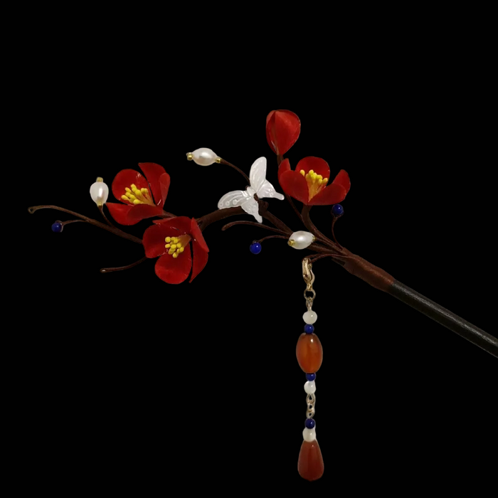 Close-up of vibrant red silk velvet plum blossoms and butterfly details on Ronghua hairpin