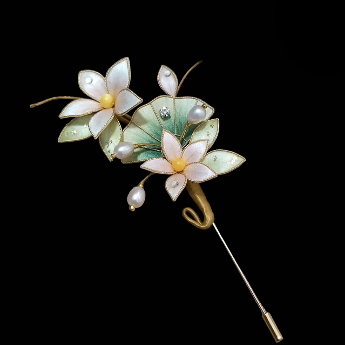 Close-up of delicate white and pink Ronghua velvet flowers with gold trim and pearls on brooch