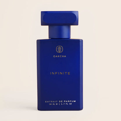 Front view of Infinite men’s perfume bottle showing deep cobalt-blue rectangular bottle and cap on a light beige background