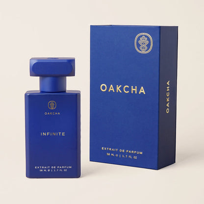Front view of Infinite fragrance bottle and box showing matte blue bottle with gold Oakcha logo on beige background