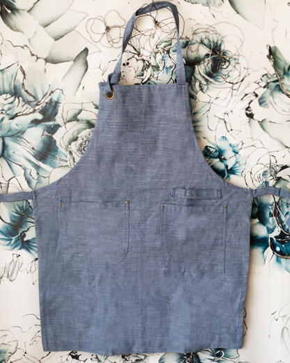 Blue chambray baker's apron with two front pockets.