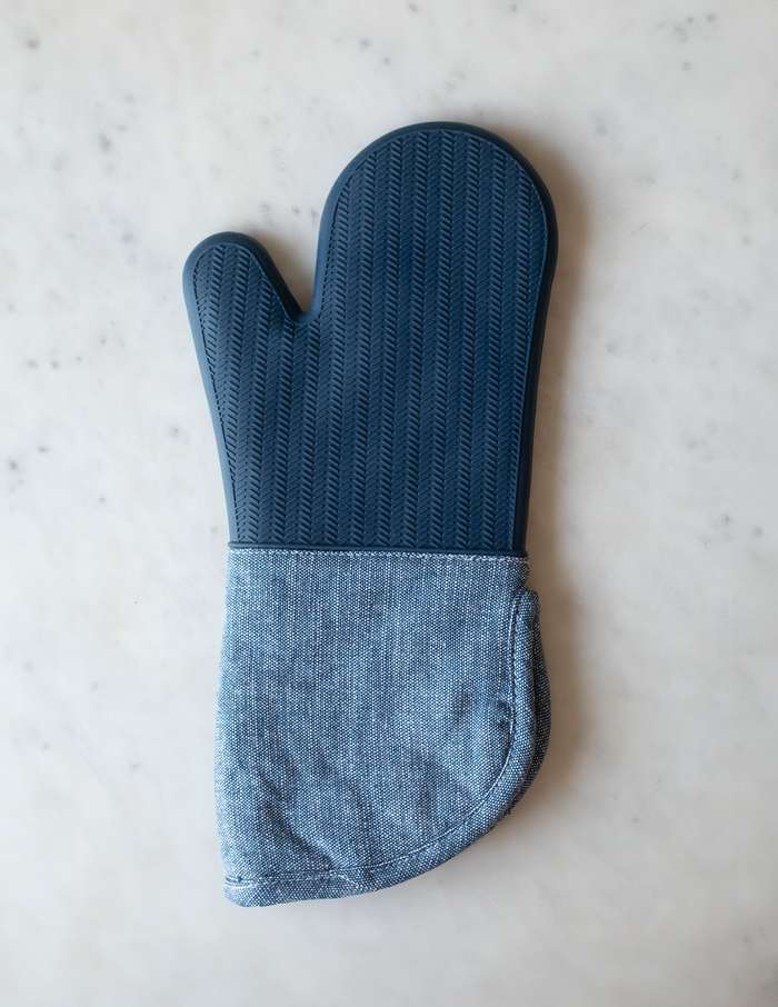 Blue silicone oven mitt with a textured grip and a light blue fabric cuff.