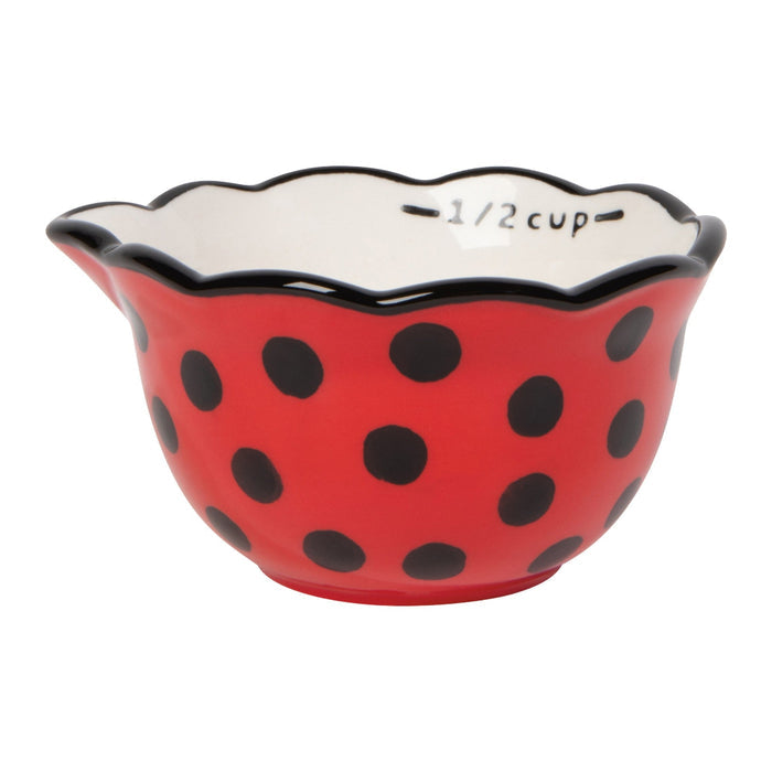 Red ceramic bowl with black polka dots and scalloped edge on a white background