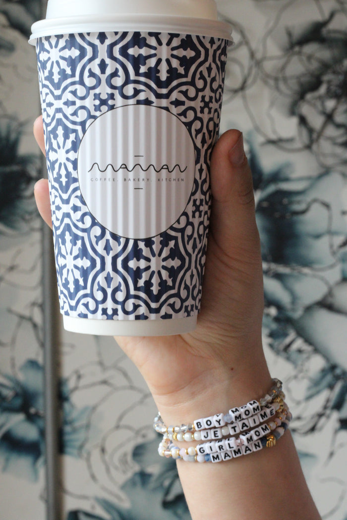 "je t'aime"; "boy mom"; "girl mom" and "maman" maman x Little Words Project bracelets worn on wrist.