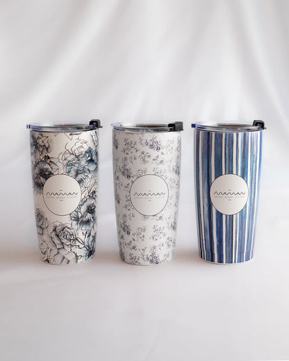 Stainless steel tumblers with floral, toile, and striped patterns in blue and white, featuring the round “Maman” logo.