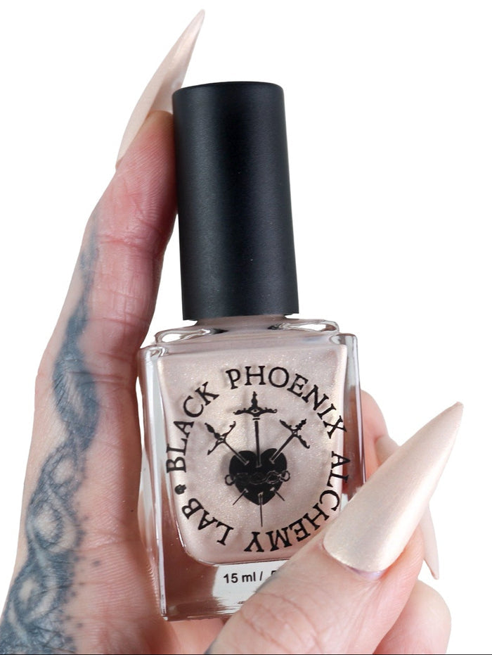 Hand holding a bottle of Black Phoenix Alchemy Lab nail polish with a white background