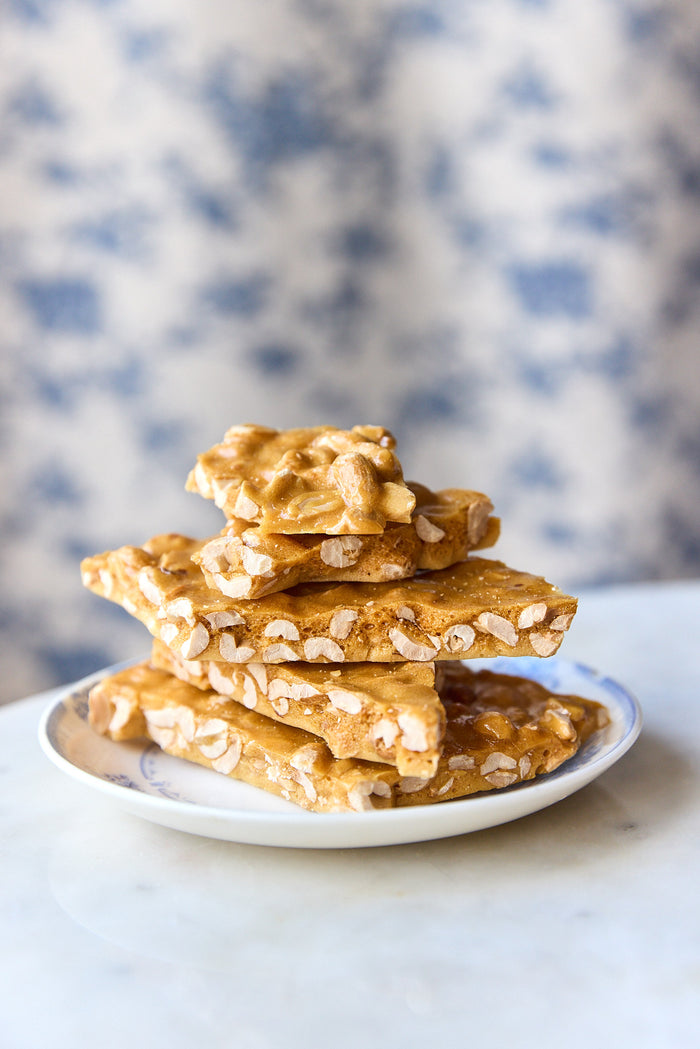 Stack of peanut brittle on a white plate.