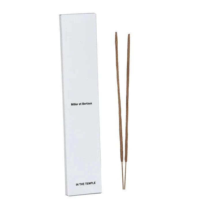 A tall white rectangular box labeled 'Miller et Bertaux' and 'IN THE TEMPLE' stands next to two incense sticks on a white background.