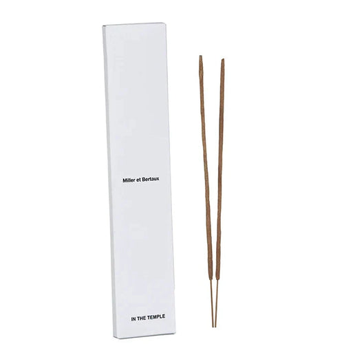 A tall white rectangular box labeled 'Miller et Bertaux' and 'IN THE TEMPLE' stands next to two incense sticks on a white background.