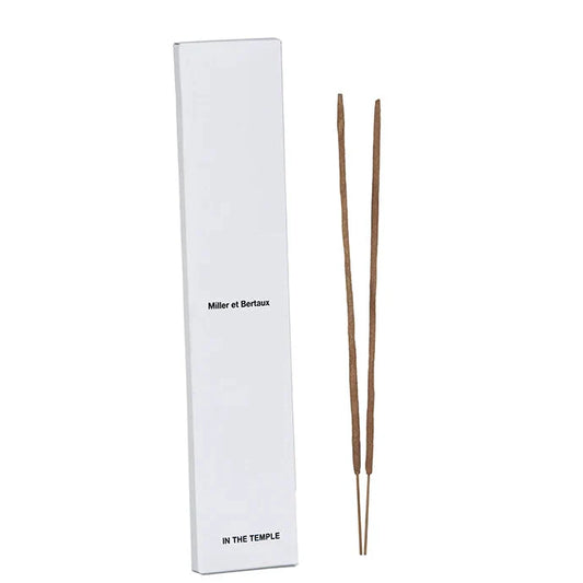 A tall white rectangular box labeled 'Miller et Bertaux' and 'IN THE TEMPLE' stands next to two incense sticks on a white background.