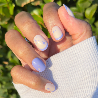 Mixed Purple Sparkle | Extra Short | Round - Tab Press-On nails with violet French tips and starry sparkle design on natural nails outdoors