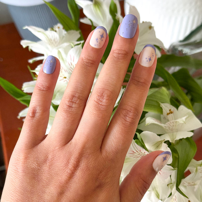 Mixed Purple Sparkle | Extra Short | Round - Tab Press-On nails with violet and starry French design on natural base over floral background