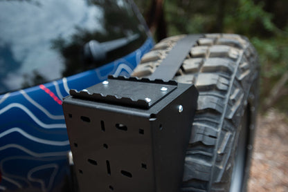Close-up of a tire carrier mounted on the rear of an off-road vehicle.