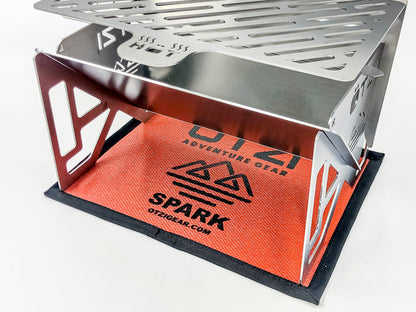 Stainless steel portable camping stove on red OTZI Gear mat
