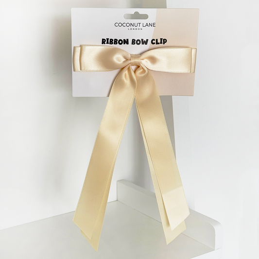 Butter yellow ribbon bow clip with long tails on Coconut Lane branded packaging.