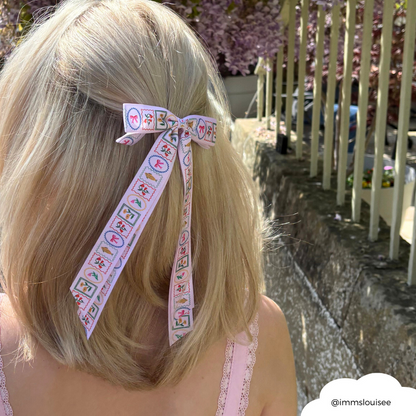 Blonde woman outside by a stone wall wears a Coconut Lane Dolce Vita ribbon bow hair clip.