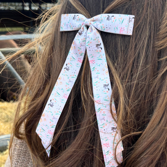 White ribbon bow clip with bunny and floral print.