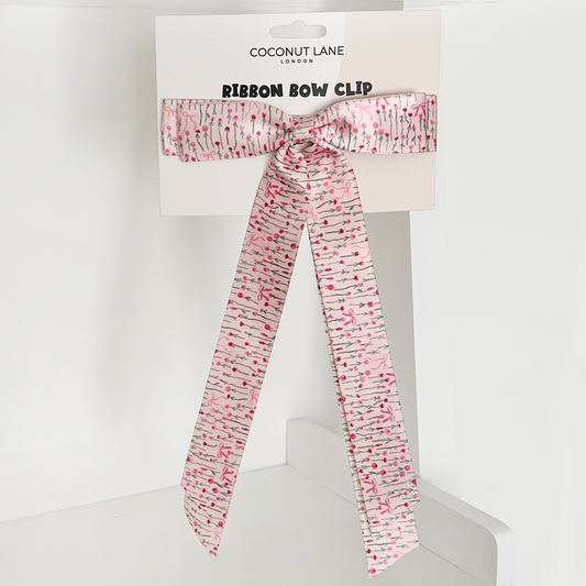 Pink satin ribbon bow clip with cherry pattern on a Coconut Lane branded display card.