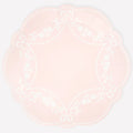 Round pink plate with white pattern on a light white background