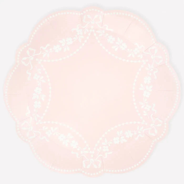 Round pink plate with white pattern on a light white background