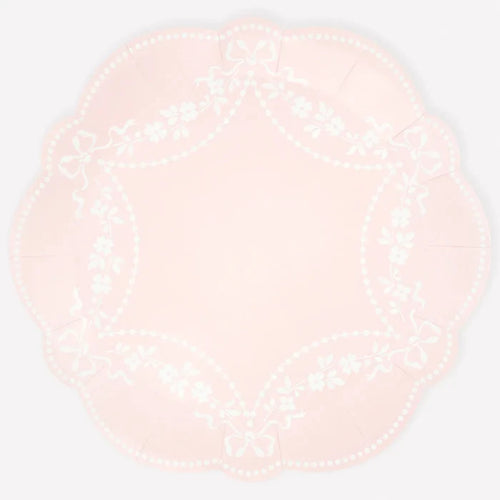 Round pink plate with white pattern on a light white background